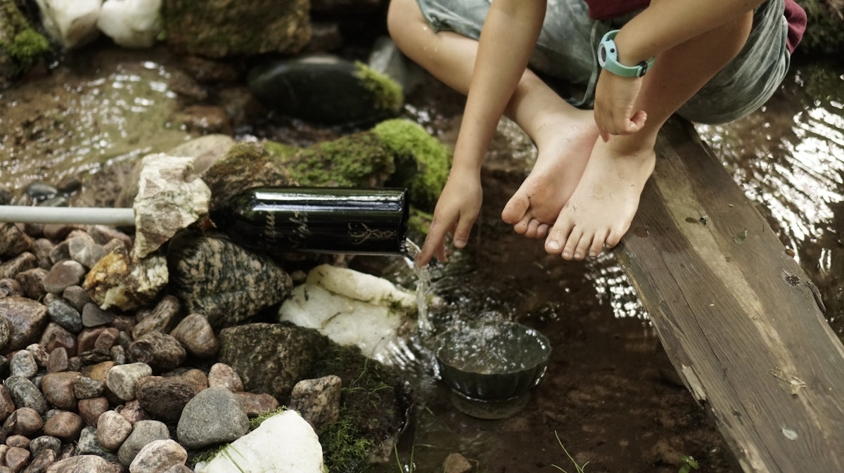 a person standing over a small stream of water